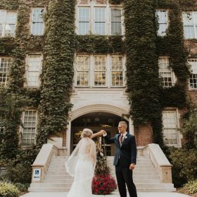 Bride and groom posing on the historic Aquinas College campus in Grand Rapids, MI