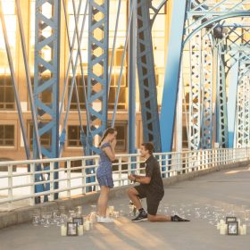 Couple celebrating their engagement on the iconic Blue Bridge in Grand Rapids, MI