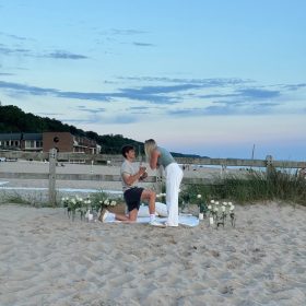 holland-state-park-beach-engagement-photo.jpg Couple celebrating their beach proposal on the sand at Holland State Park