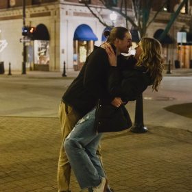Engaged couple posing at Rosa Parks Circle in downtown Grand Rapids
